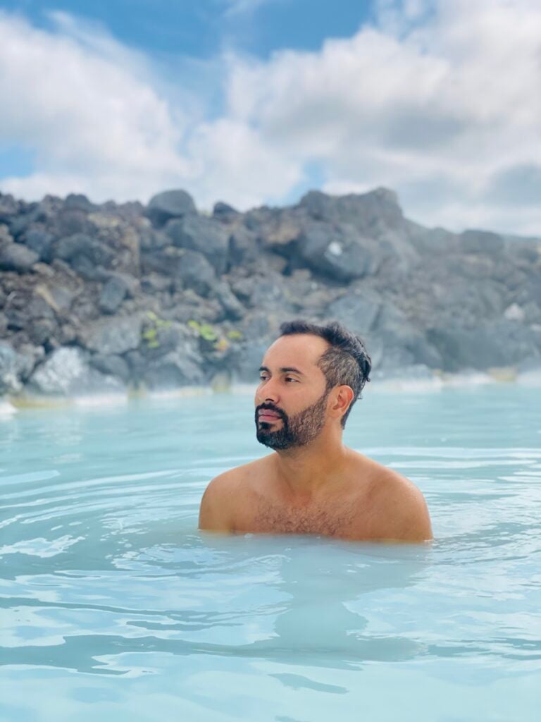 Relaxing in the Blue Lagoon’s geothermal water with lava rock behind