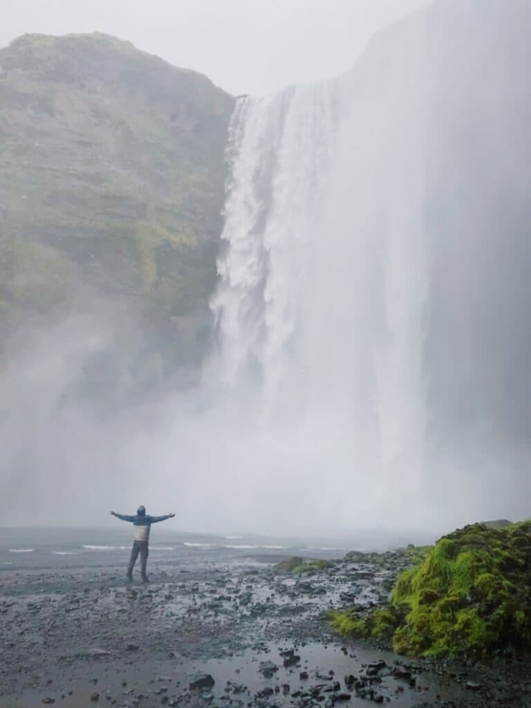Standing in the mist in front of a waterfall on Iceland’s south coast